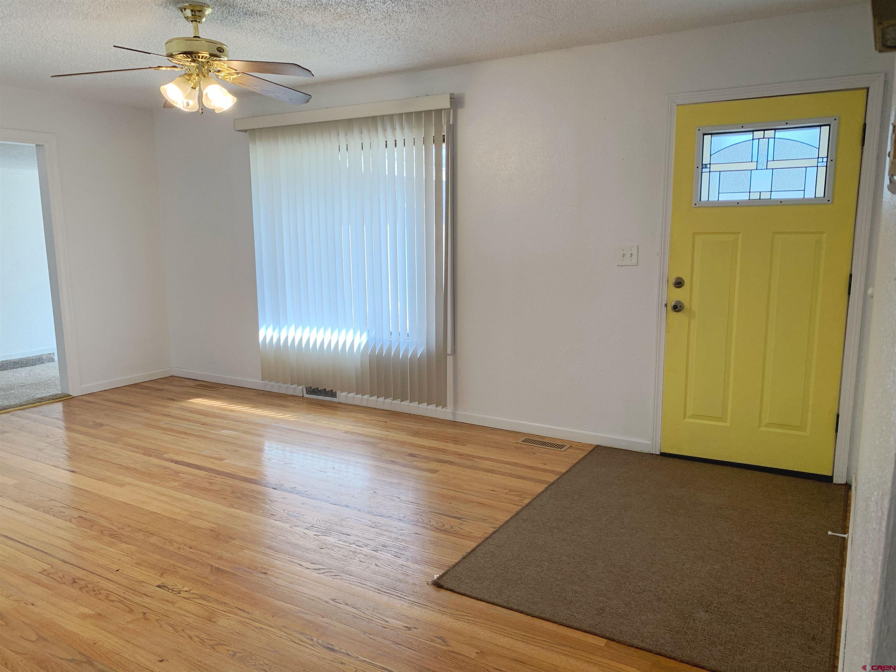 331 Morris Street Monte Vista, CO 81144 - Photo 2 of 31 wooden floor in an empty room with a window