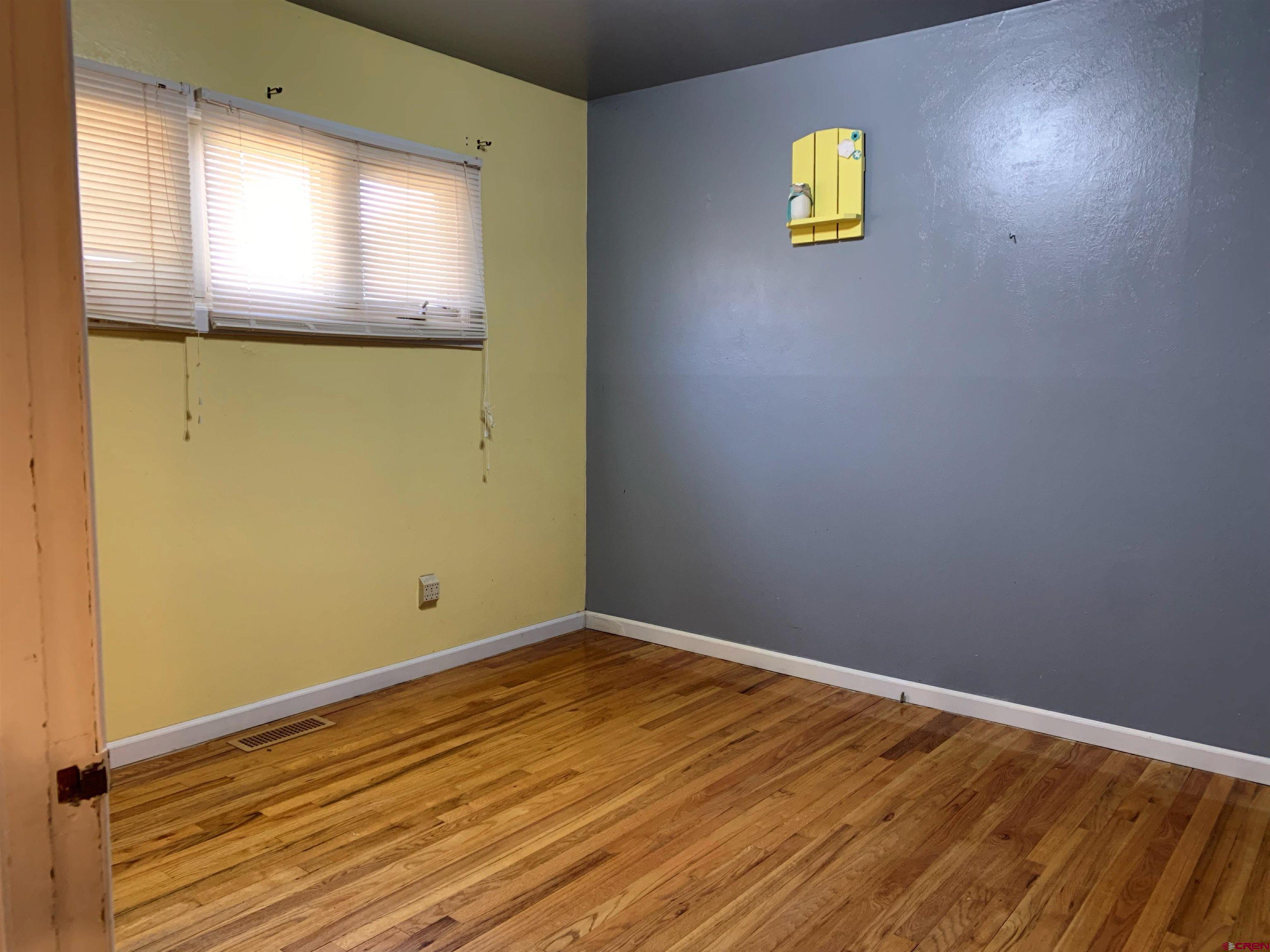 331 Morris Street Monte Vista, CO 81144 - Photo 24 of 31 a view of an empty room with window and wooden floor