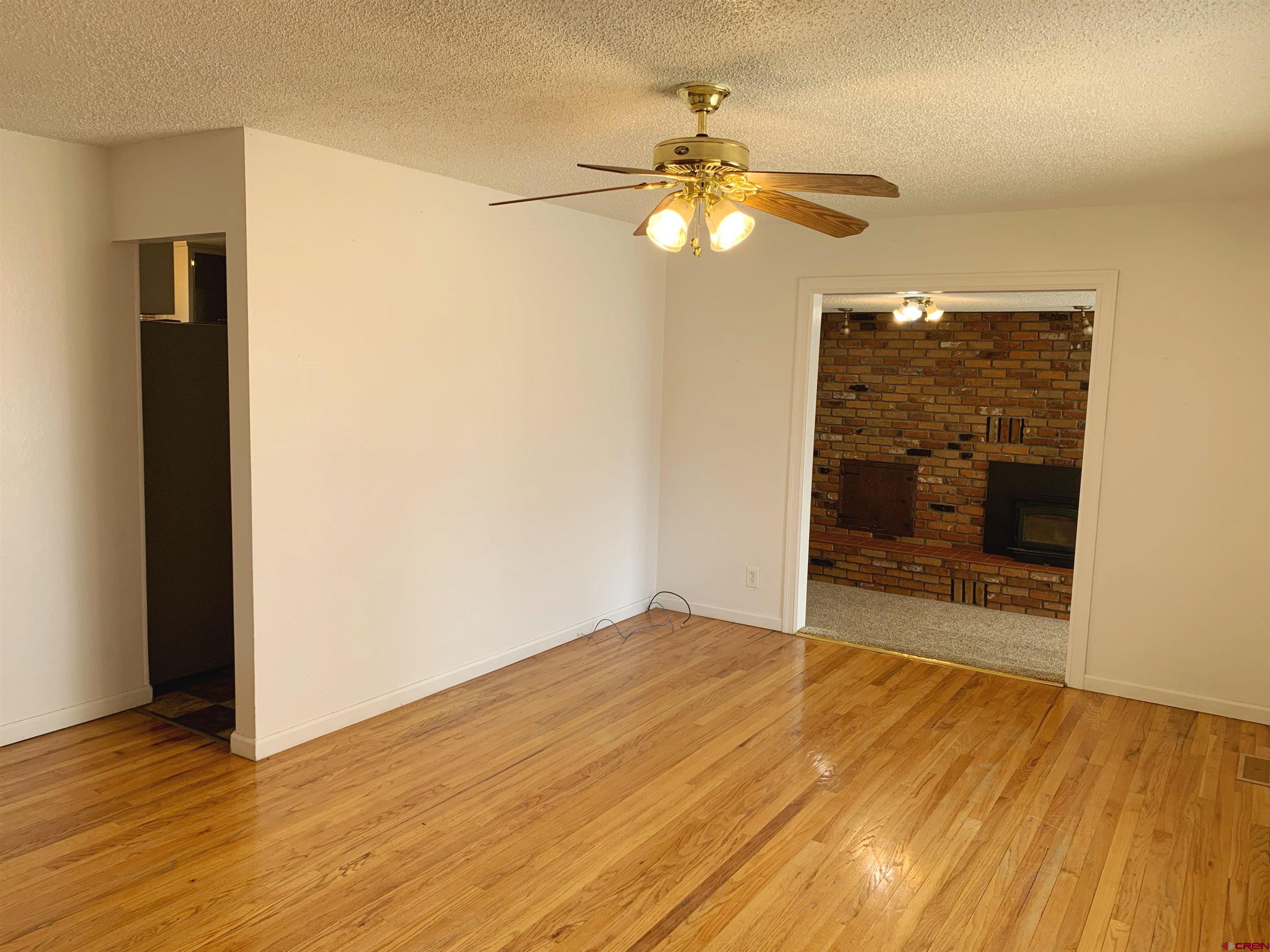 331 Morris Street Monte Vista, CO 81144 - Photo 4 of 31 a view of an empty room with wooden floor and a window