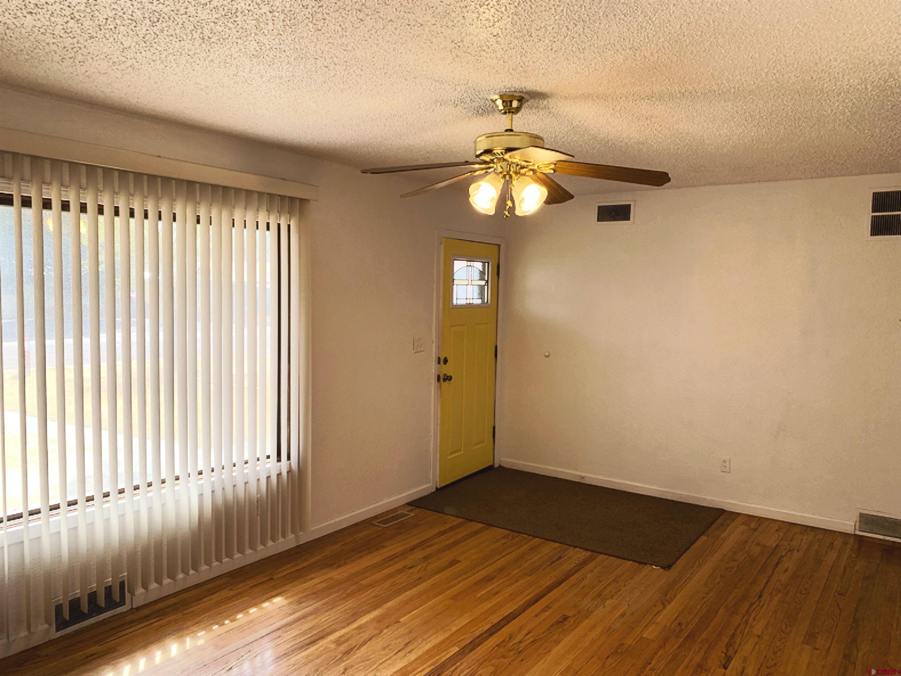 331 Morris Street Monte Vista, CO 81144 - Photo 5 of 31 an empty room with wooden floor and windows