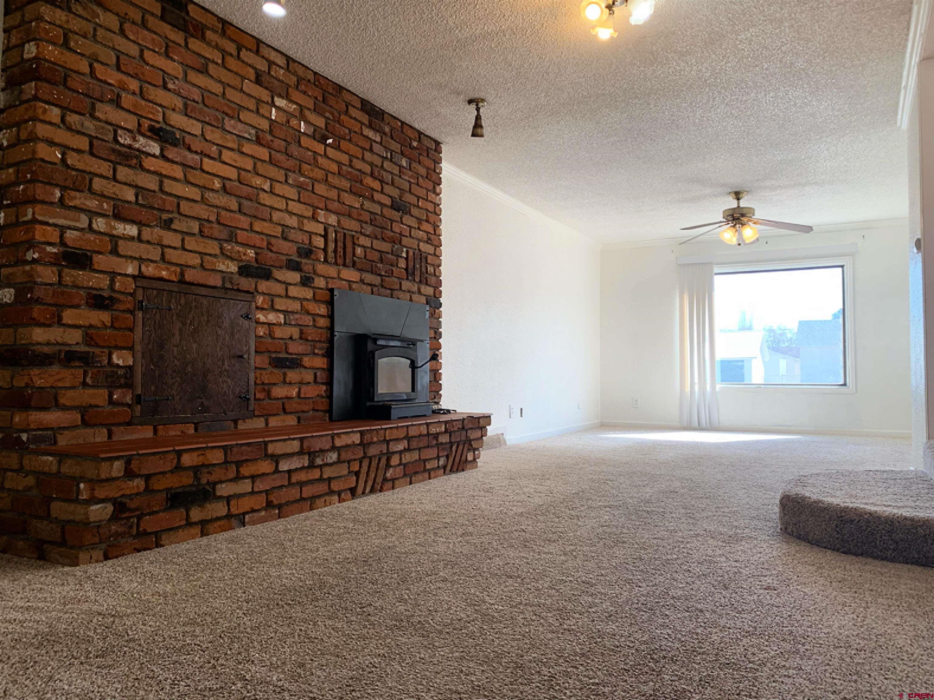 331 Morris Street Monte Vista, CO 81144 - Photo 6 of 31 a living room with fireplace furniture and a window