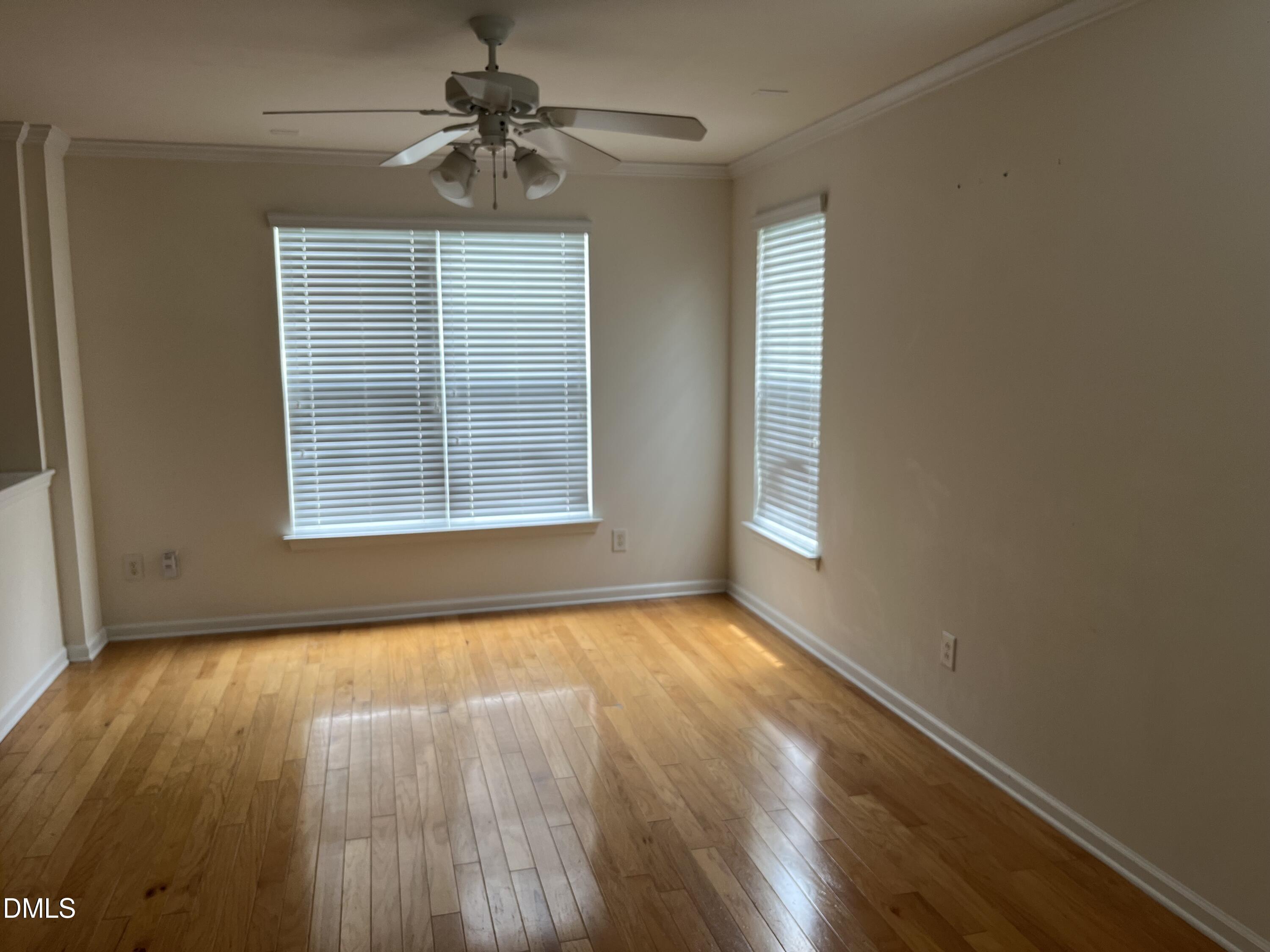 9827 Grettle Court Raleigh, NC 27617 - Photo 3 of 10 a view of an empty room with a window and wooden floor