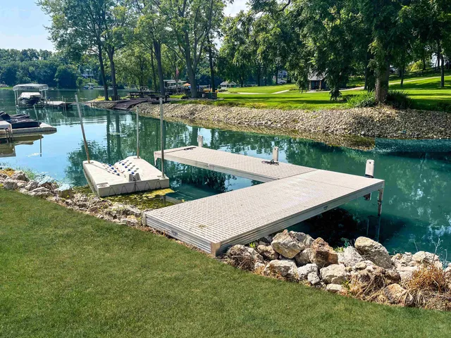 a living room with stainless steel appliances furniture a rug kitchen view and a chandelier