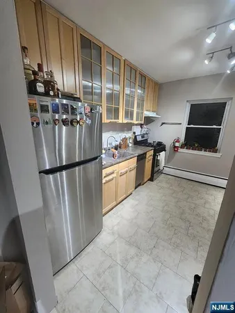 a kitchen with stainless steel appliances granite countertop a refrigerator a stove a sink and a microwave