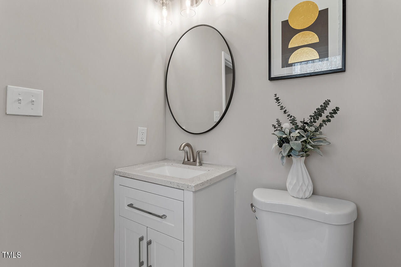 5137 Shield Circle Raleigh, NC 27603 - Photo 19 of 36 a bathroom with a toilet sink and mirror