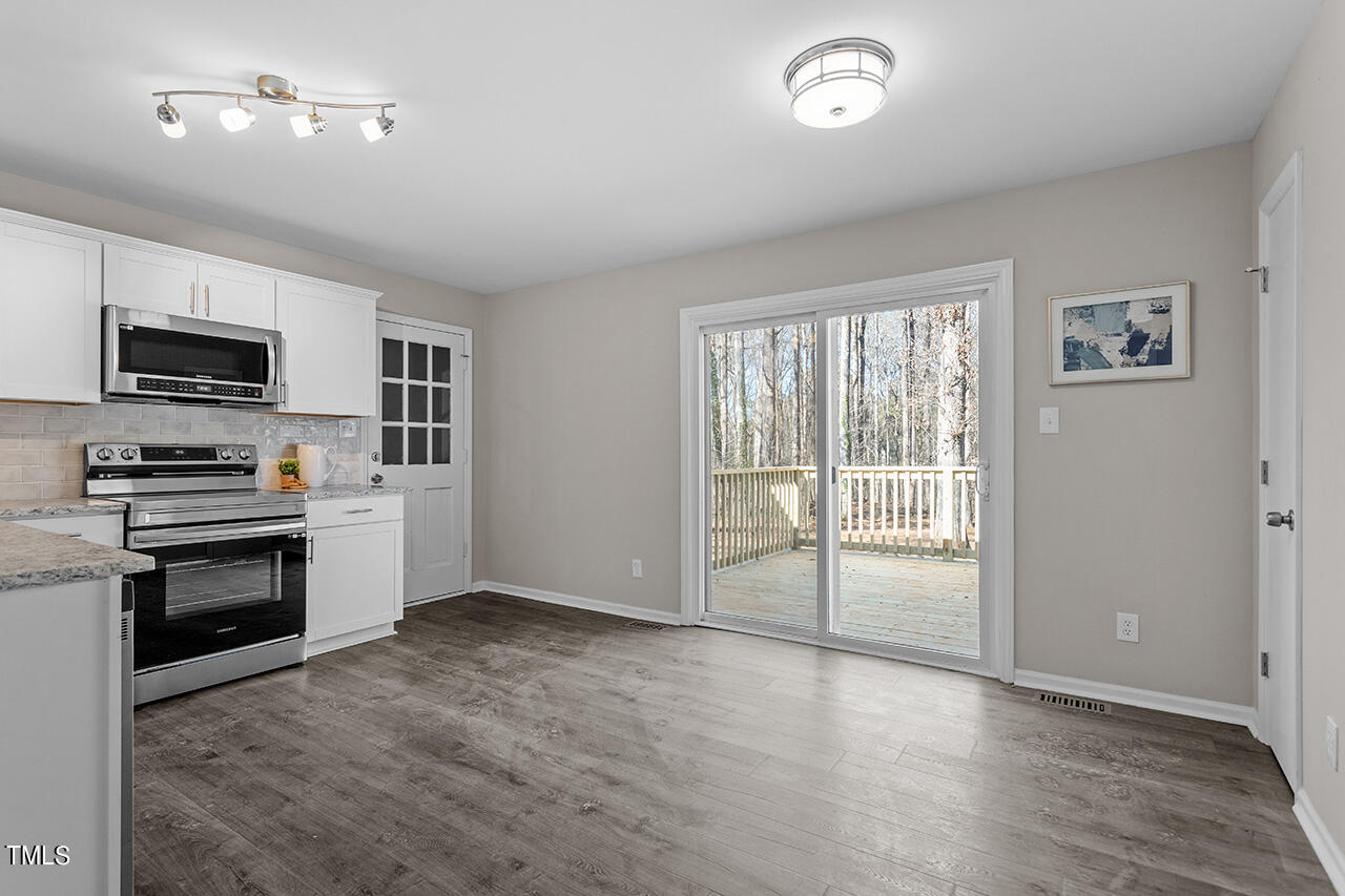 5137 Shield Circle Raleigh, NC 27603 - Photo 3 of 36 a kitchen with granite countertop a stove a sink and a refrigerator