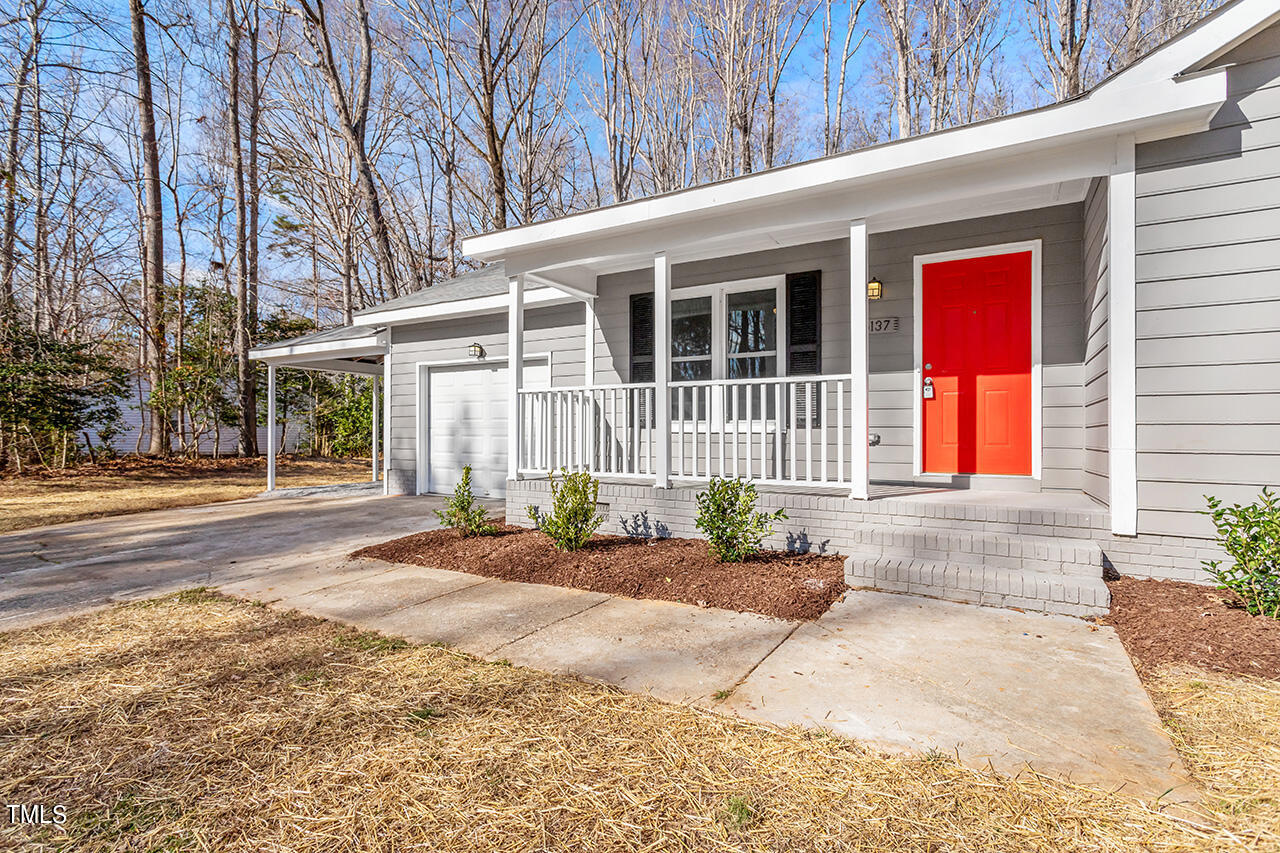 5137 Shield Circle Raleigh, NC 27603 - Photo 34 of 36 a front view of a house with a yard and potted plants