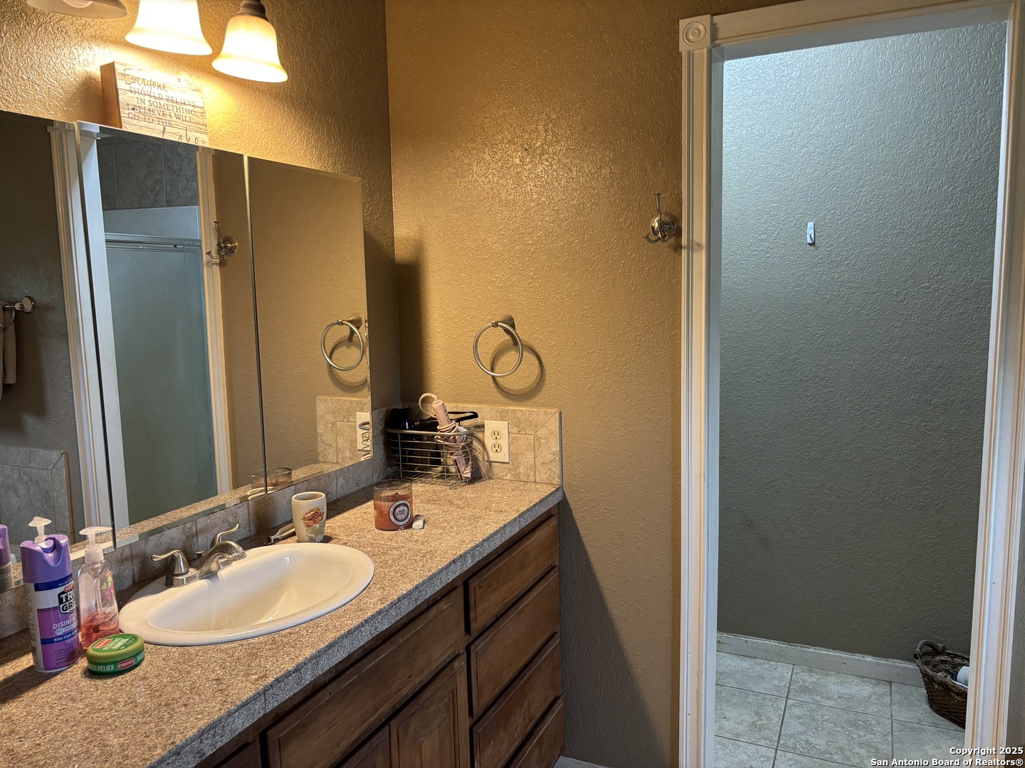 725 Lonesome Loop Blanco, TX 78606 - Photo 12 of 26 a bathroom with a granite countertop sink and a mirror