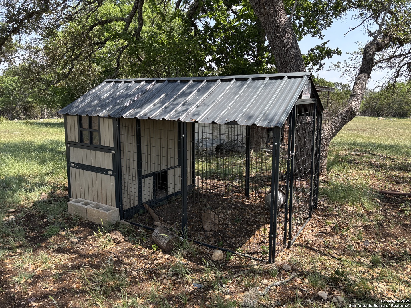 725 Lonesome Loop Blanco, TX 78606 - Photo 14 of 26 a view of a house with backyard wooden fence and a forest
