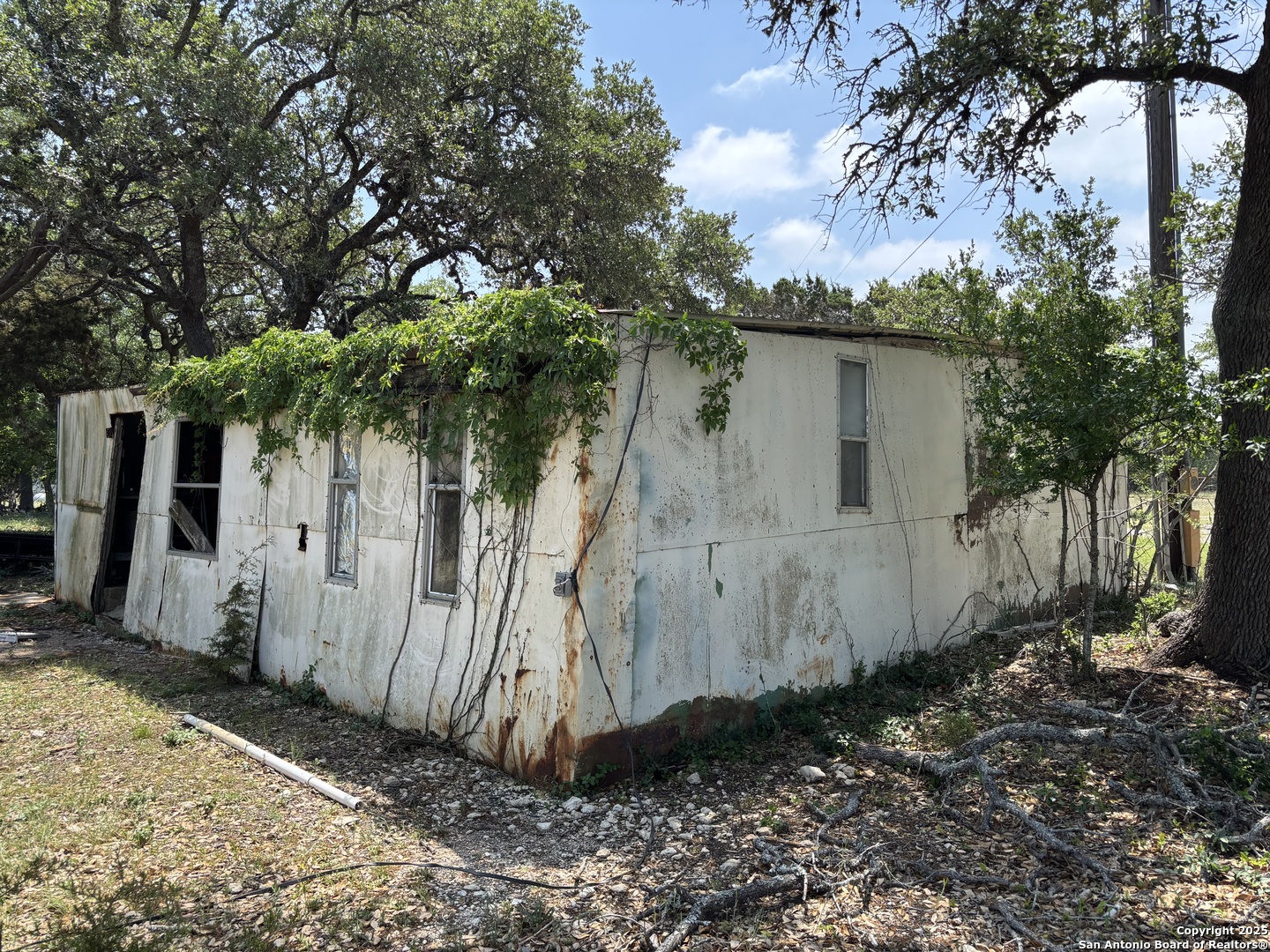 725 Lonesome Loop Blanco, TX 78606 - Photo 19 of 26 a view of a barn in the yard with large trees