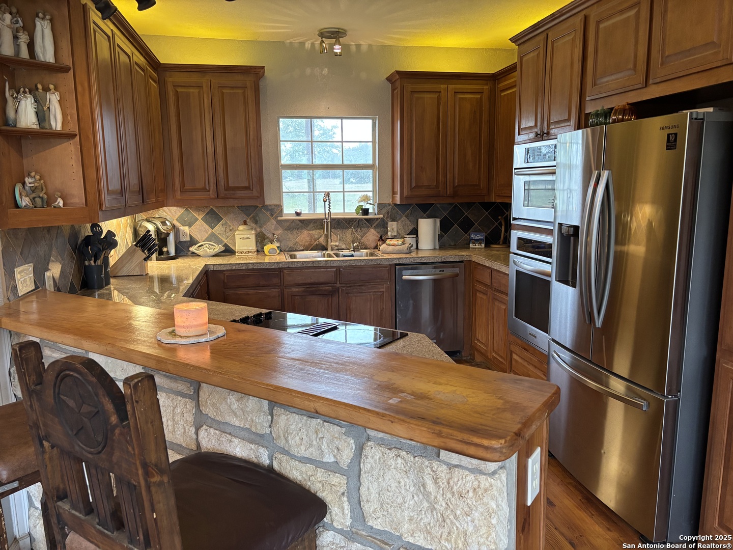 725 Lonesome Loop Blanco, TX 78606 - Photo 8 of 26 a kitchen with stainless steel appliances granite countertop a sink refrigerator and microwave
