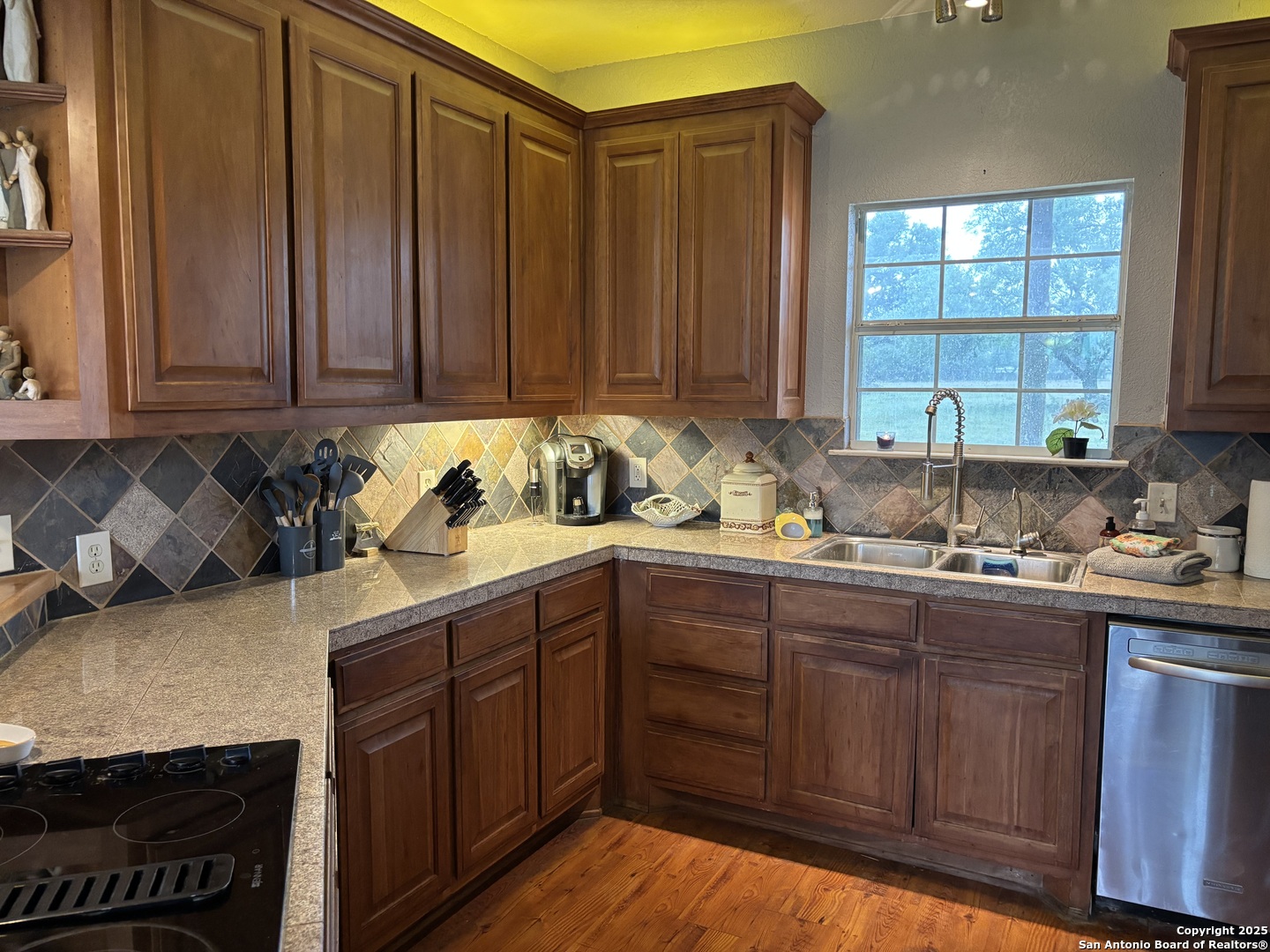 725 Lonesome Loop Blanco, TX 78606 - Photo 9 of 26 a kitchen with granite countertop wooden cabinets a sink and dishwasher