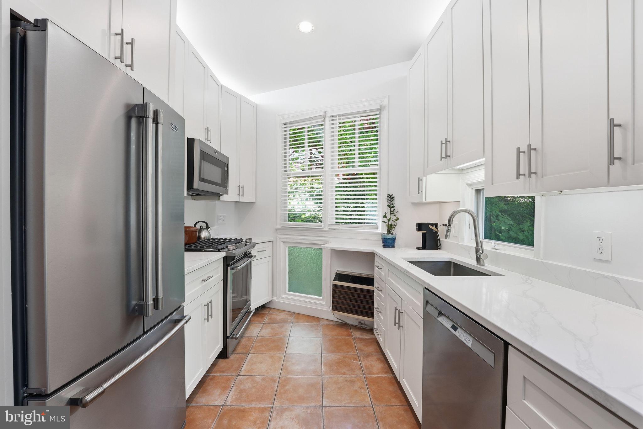3512 30th Street Northwest Washington, DC 20008 - Photo 12 of 41 a kitchen with white cabinets and stainless steel appliances