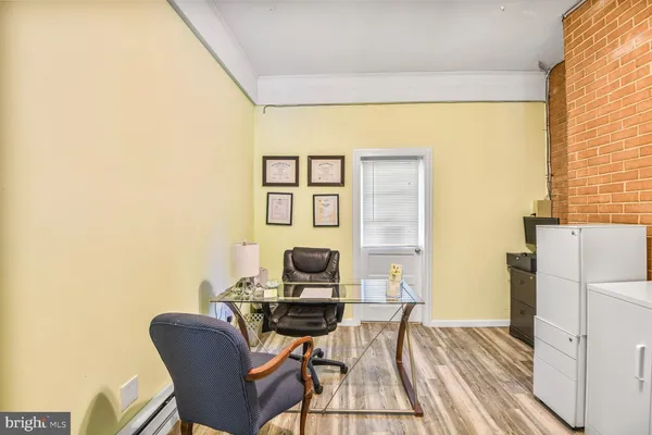 a view of a workspace with furniture and a window