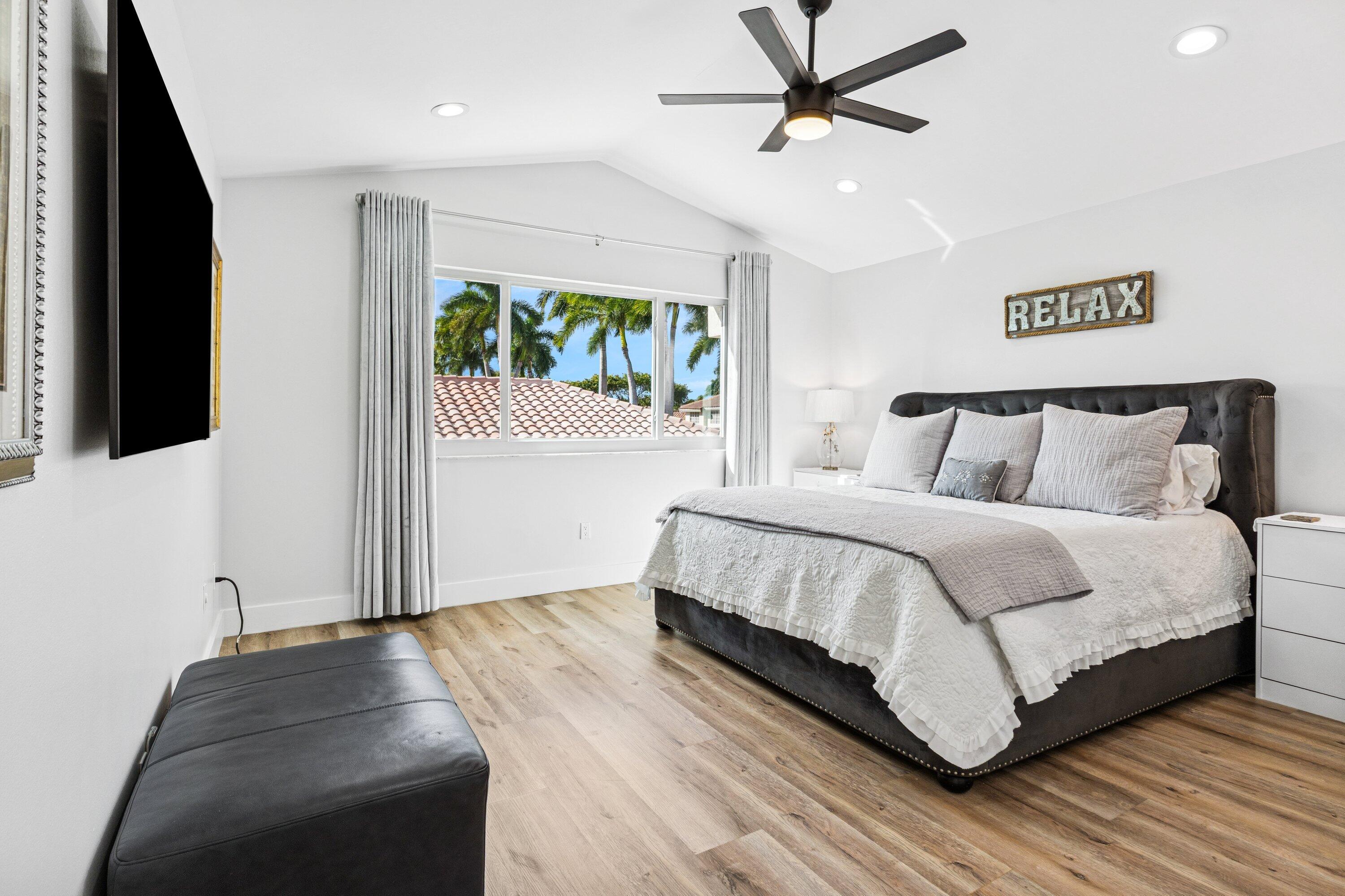 5183 Northwest 25th Way Boca Raton, FL 33496 - Photo 15 of 73 a bedroom with a bed and a flat tv screen