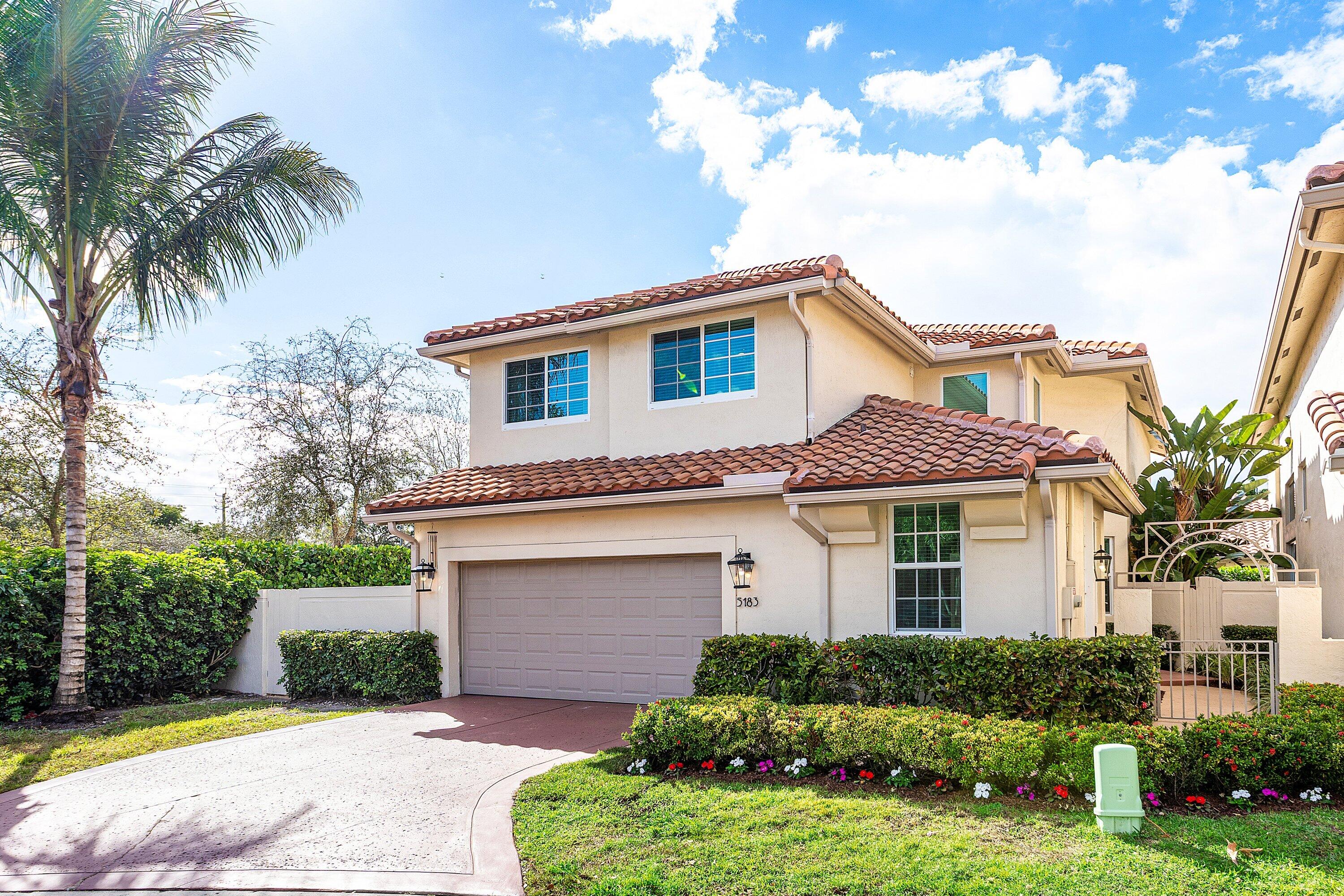5183 Northwest 25th Way Boca Raton, FL 33496 - Photo 2 of 73 a front view of a house with a garden