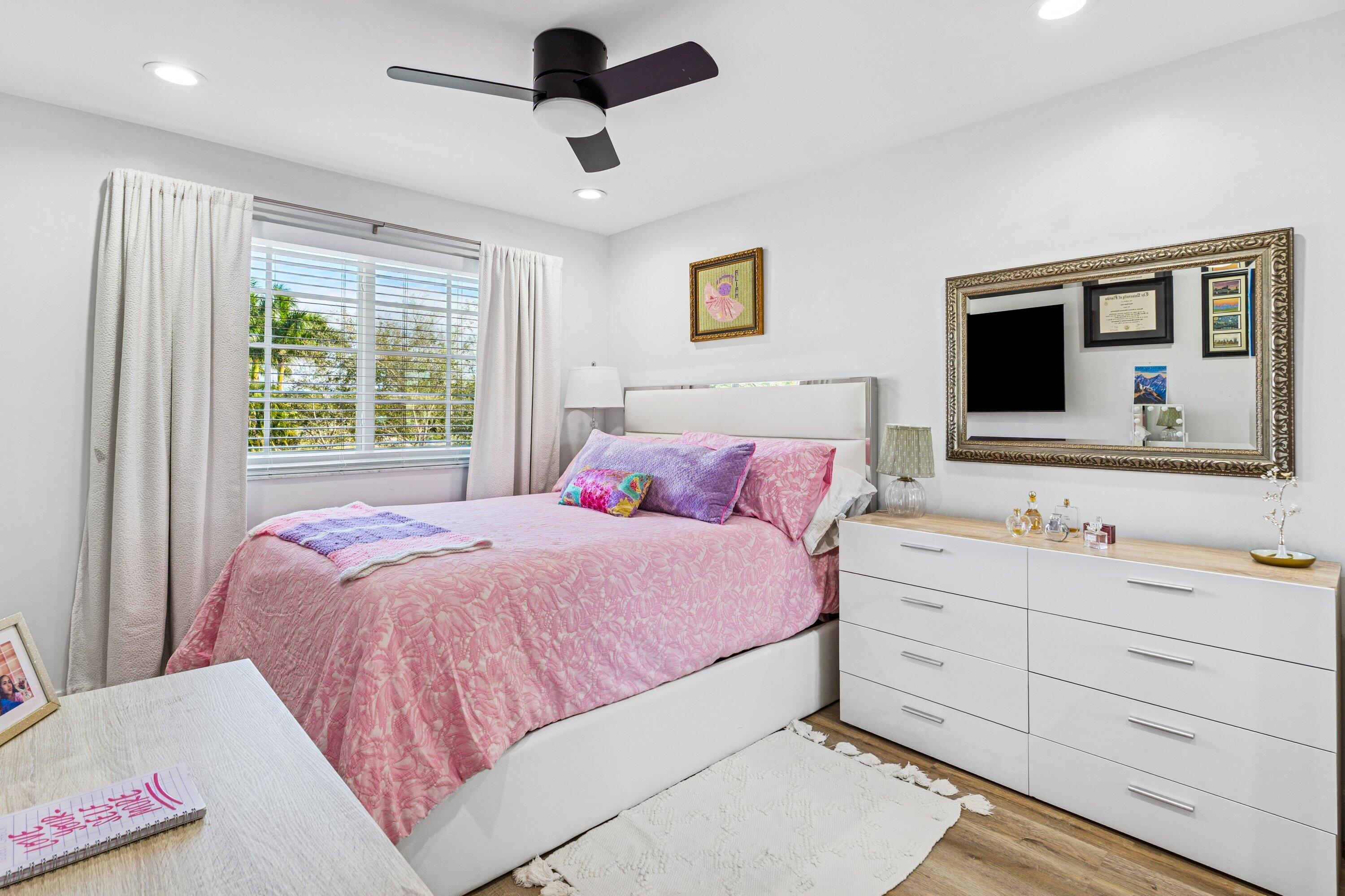 5183 Northwest 25th Way Boca Raton, FL 33496 - Photo 21 of 73 a bedroom with a large bed and a flat screen tv