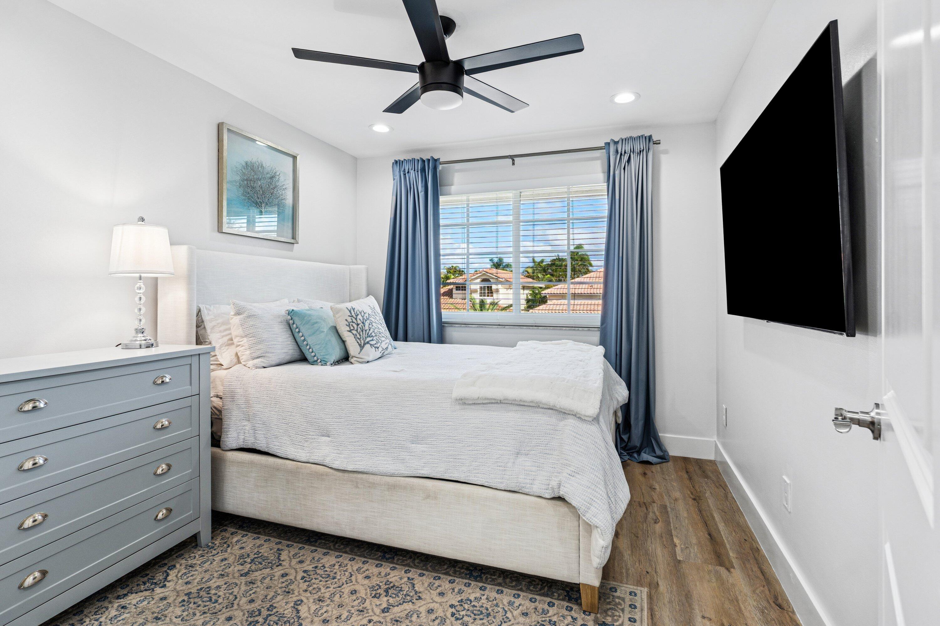 5183 Northwest 25th Way Boca Raton, FL 33496 - Photo 24 of 73 a bedroom with a bed and a flat tv screen on dresser