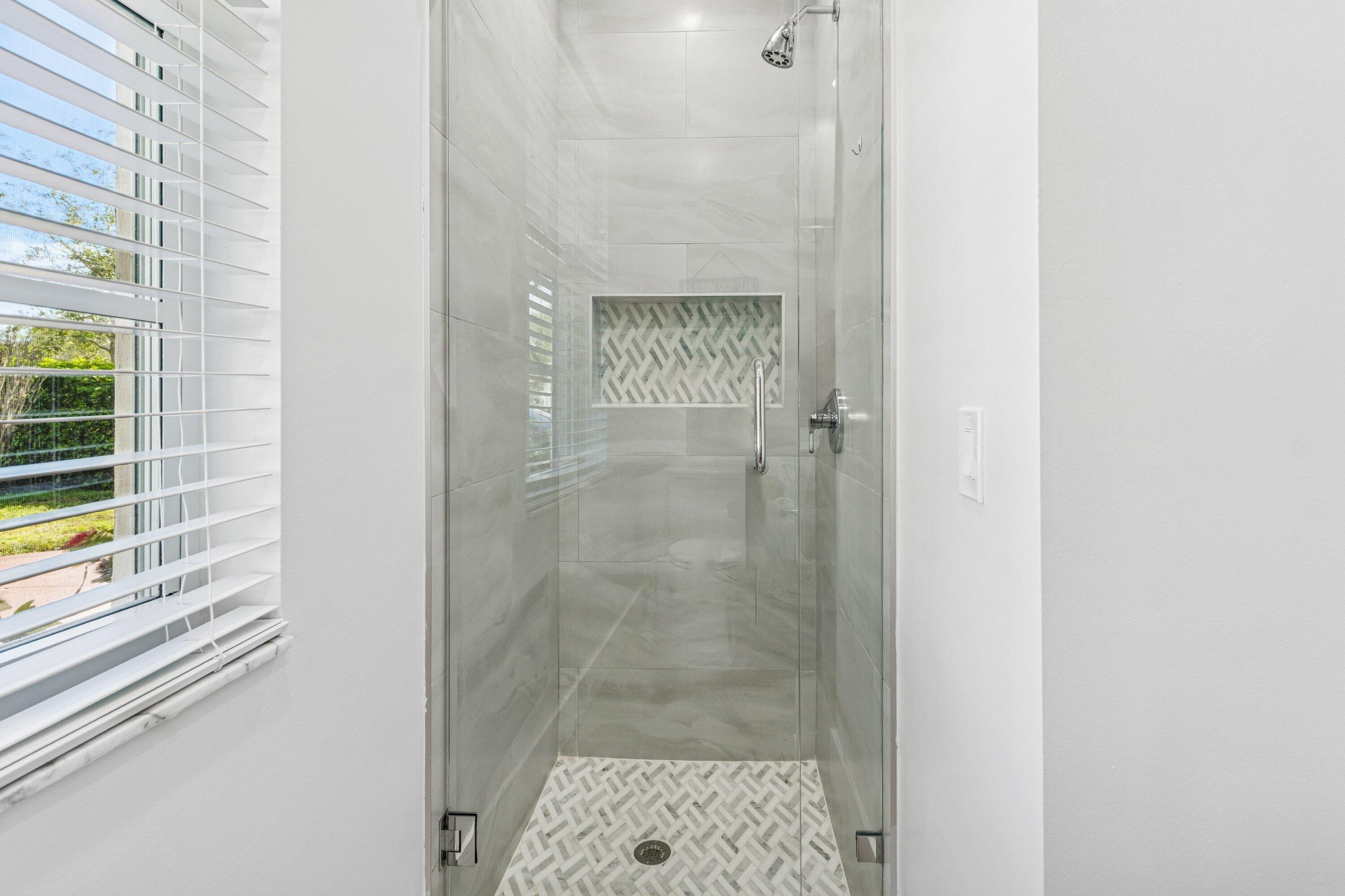 5183 Northwest 25th Way Boca Raton, FL 33496 - Photo 27 of 73 a bathroom with a glass shower door
