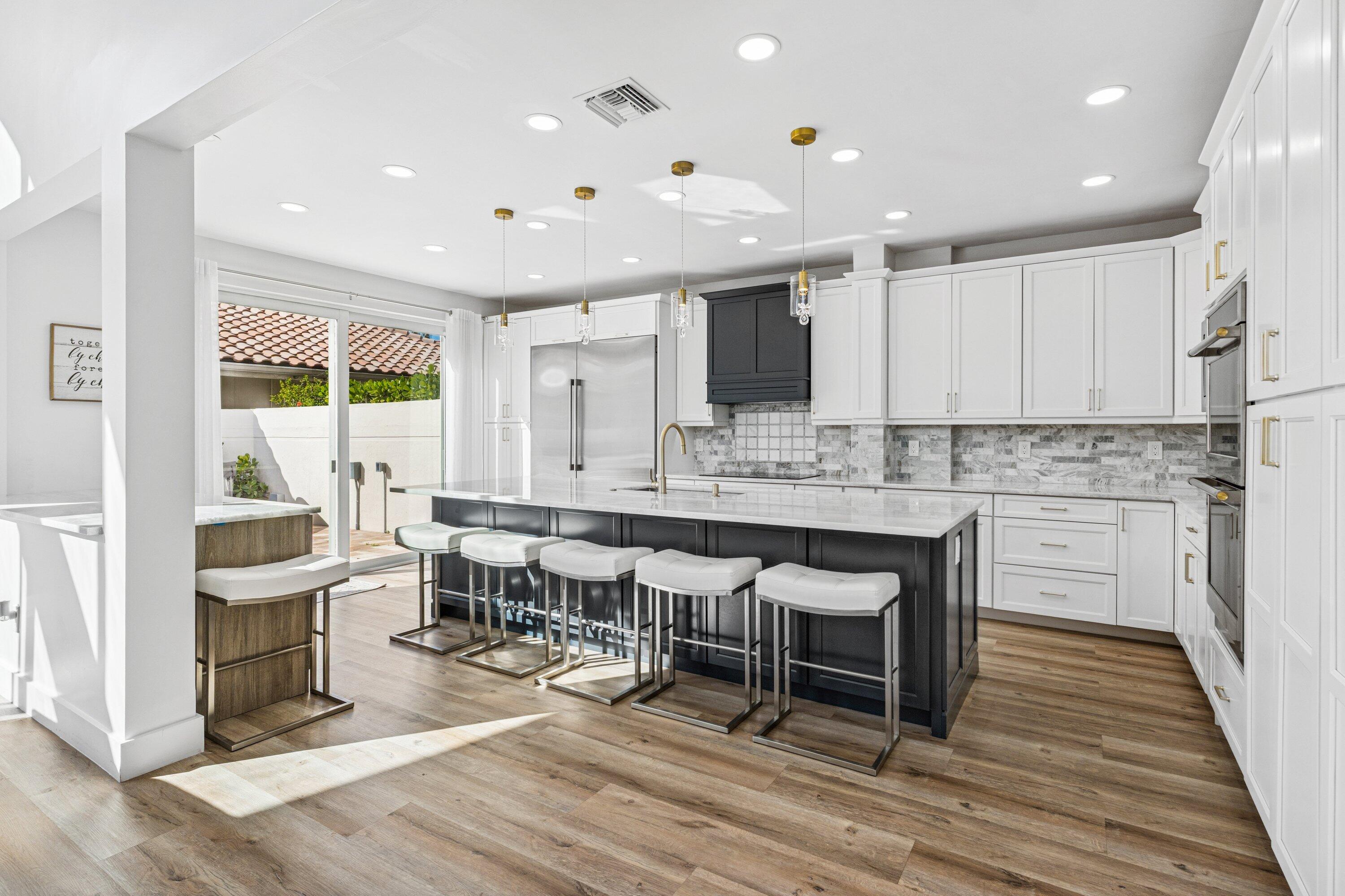 5183 Northwest 25th Way Boca Raton, FL 33496 - Photo 10 of 73 a large dining hall with stainless steel appliances granite countertop a stove a sink dishwasher a dining table and chairs with wooden floor