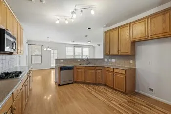 a large kitchen with cabinets wooden floor and stainless steel appliances