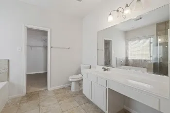 a bathroom with a sink a toilet and large mirror