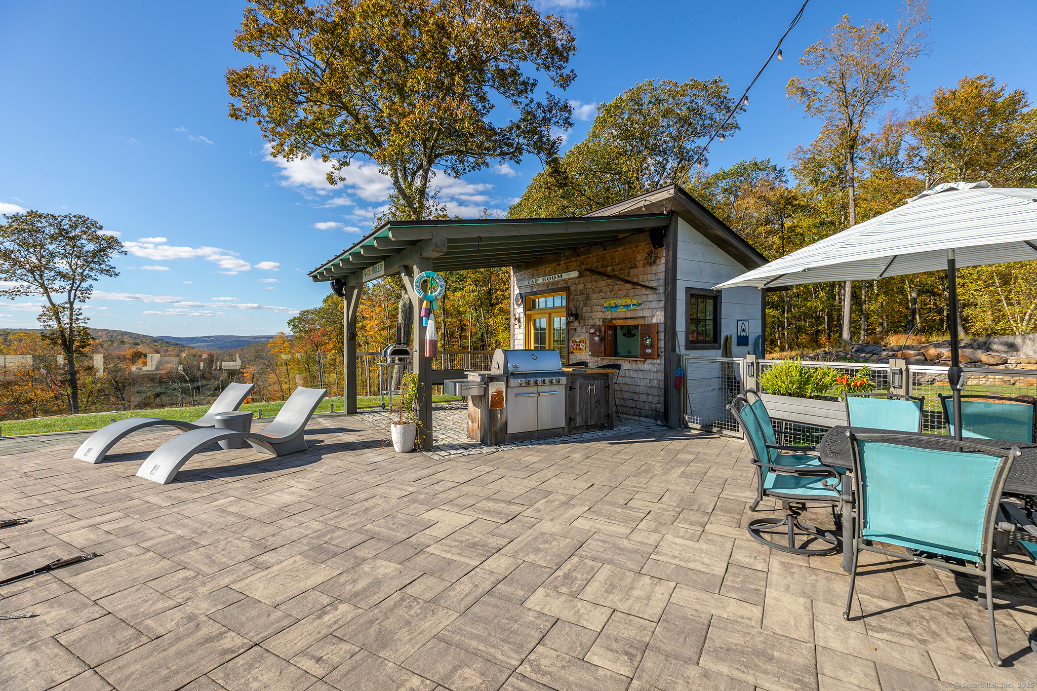 8 Bobcat Lane Warren, CT 06754 - Photo 20 of 40 a view of a patio with a table and chairs under an umbrella