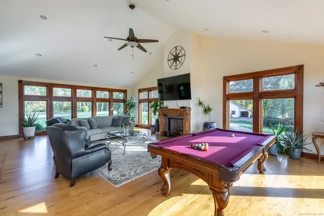 a living room with furniture a flat screen tv and a floor to ceiling window