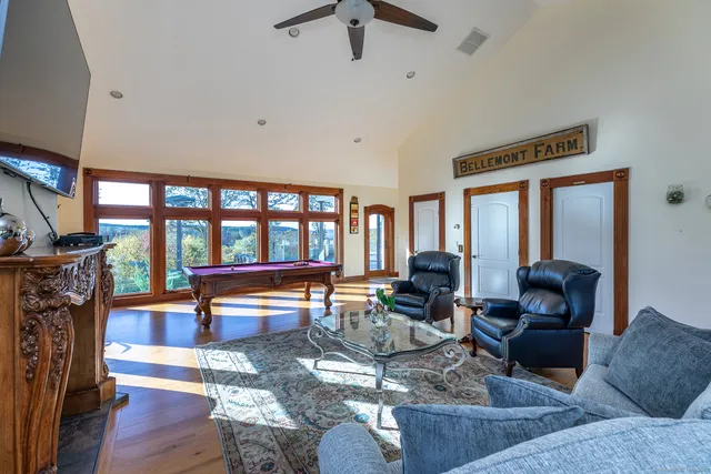 a living room with furniture a fireplace and a floor to ceiling window
