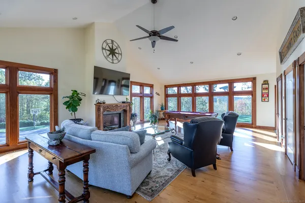 a living room with fireplace furniture and a large window