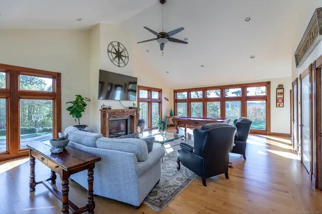 a living room with fireplace furniture and a large window