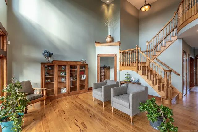 a view of a livingroom with wooden furniture and staircase