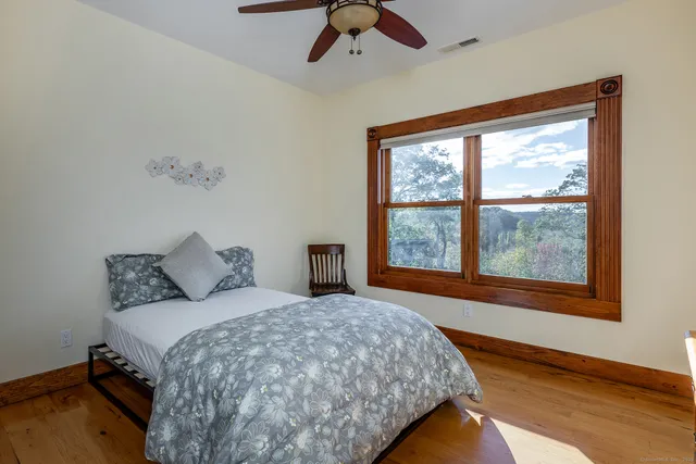 a bedroom with a bed and a large window