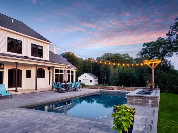 a view of a house with pool and chairs