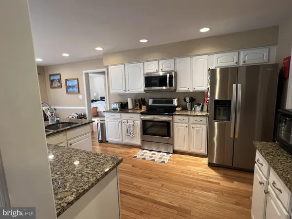 a kitchen with sink stove and wooden floor