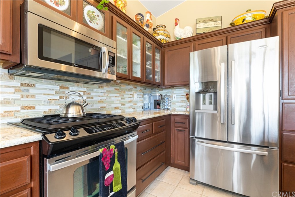 1612 Via Flora Paso Robles, CA 93446 - Photo 8 of 35 a kitchen with stainless steel appliances granite countertop a stove a refrigerator and a microwave