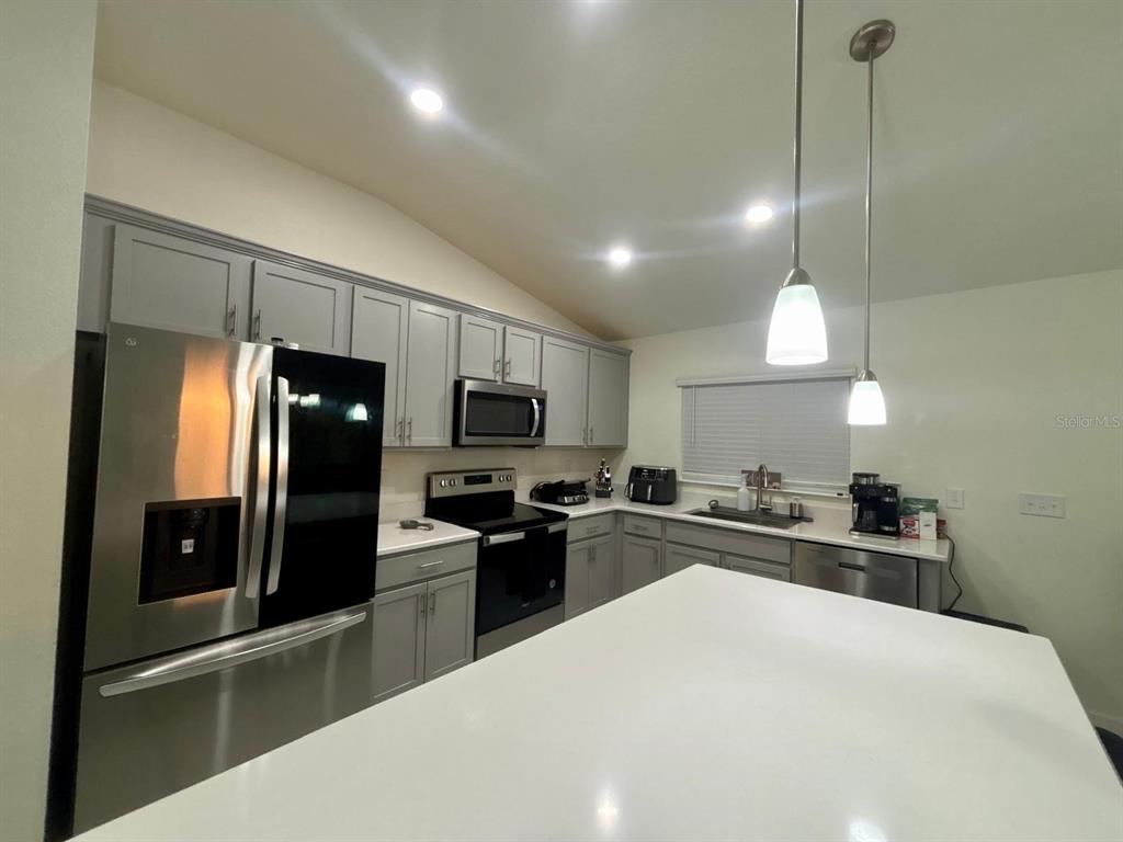 3166 Sweet Acrs Place St. Cloud, FL 34772 - Photo 4 of 27 a kitchen with black cabinets and stainless steel appliances