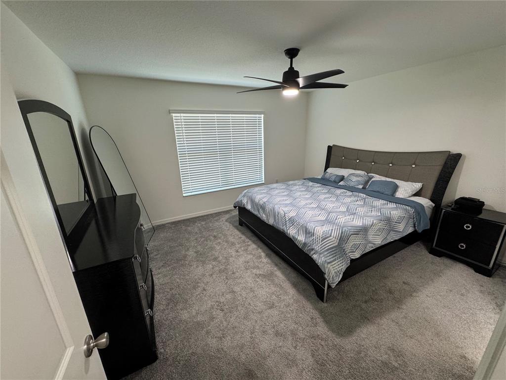 3166 Sweet Acrs Place St. Cloud, FL 34772 - Photo 10 of 27 a bedroom with a bed and a large mirror