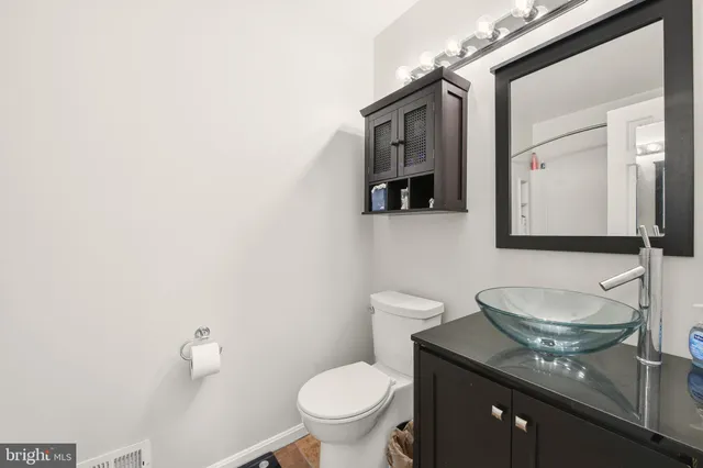 a bathroom with a granite countertop toilet sink and mirror