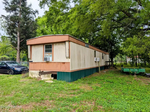 a front view of a house with a yard and trees