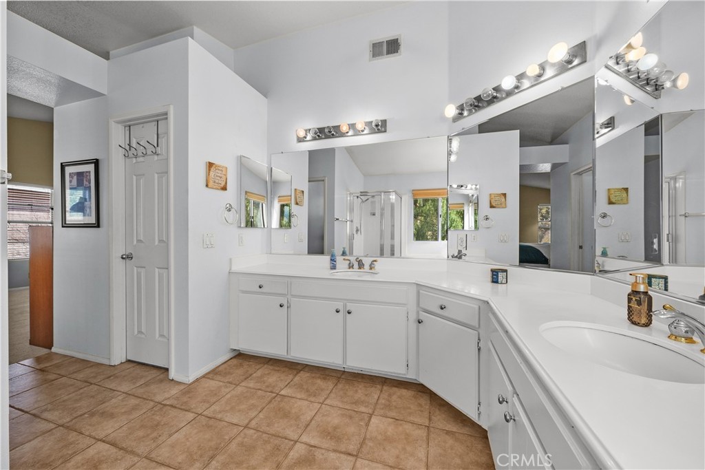 27687 Ron Ridge Drive Saugus, CA 91350 - Photo 25 of 50 a spacious bathroom with a granite countertop sink a mirror a shower and bathtub