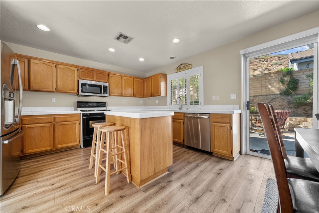 27687 Ron Ridge Drive Saugus, CA 91350 - Photo 8 of 50 a kitchen with a sink a counter top space stainless steel appliances and cabinets