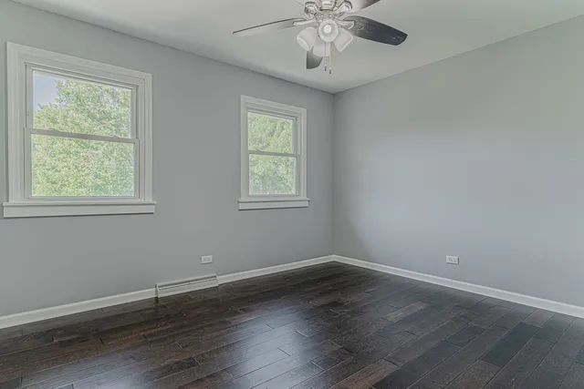 a view of a room with wooden floor and windows