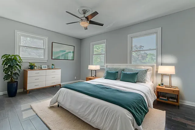 a bedroom with a bed a couch and potted plant