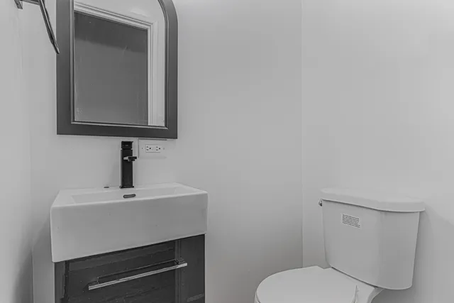 a bathroom with a toilet sink and mirror