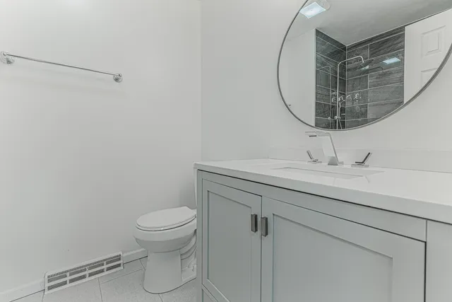 a bathroom with a sink a toilet and a mirror