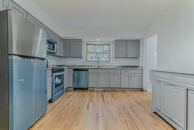 a kitchen with stainless steel appliances granite countertop a stove a sink dishwasher and a refrigerator