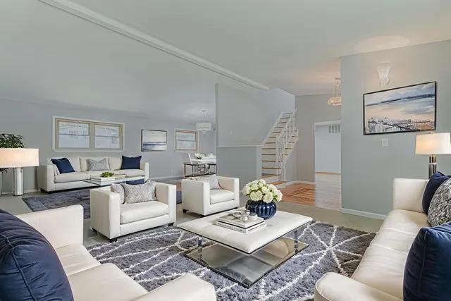 a living room with furniture a rug and a table