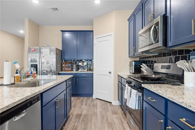 a kitchen with stainless steel appliances granite countertop a sink stove and cabinets