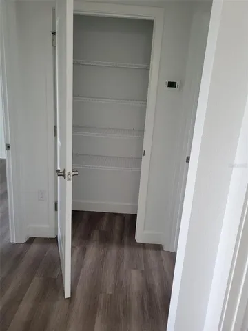 a view of walk in closet with wooden floor